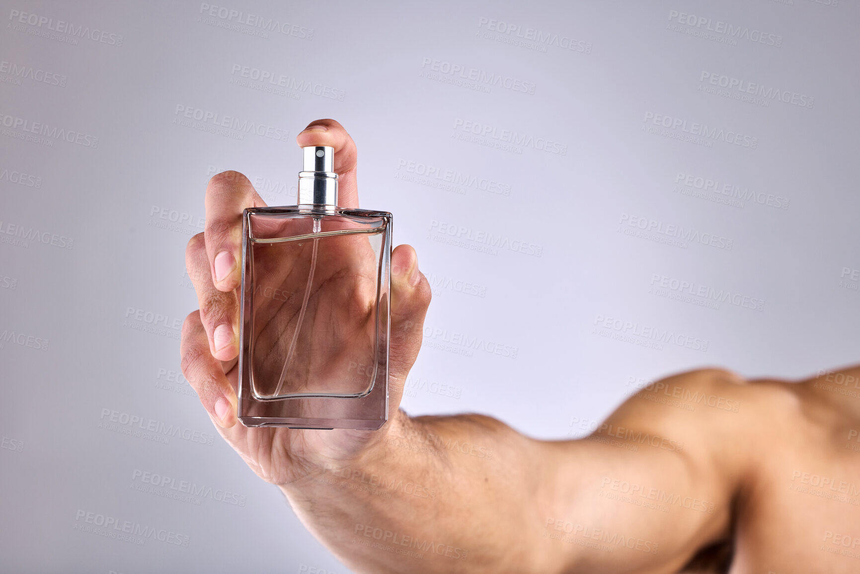 Buy stock photo Hand, bottle and cologne with a man in studio on a white background for perfume, fragrance or product. Luxury scent, spray and glass container with person for designer cosmetics, wellness and mockup