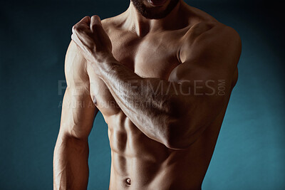 Buy stock photo Man, studio and shirtless with abdomen for strong wellness, flex with bicep for sport or fitness. Male person, dark and blue background for exercise in gym, workout with arm for body builder