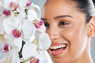 Buy stock photo Face, woman and skincare with flower in studio on white background for organic or natural cosmetics. Female person, happy and floral for skin glow, smooth and treatment with sustainability and beauty