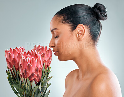 Buy stock photo Smell, woman and skincare with plant in studio on white background for organic or natural cosmetics. Female person, treatment and protea flower for skin glow, smooth and wellness for sustainability