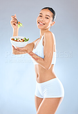 Buy stock photo Studio portrait of a beautiful young woman having a balanced breakfast while posing against a grey background