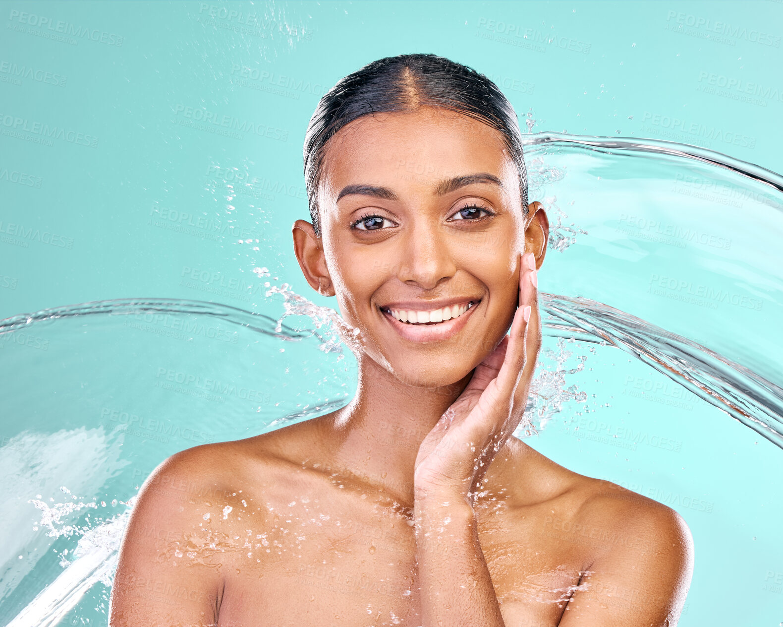 Buy stock photo Woman portrait, washing and water splash for skin care, hygiene and beauty or dermatology in studio. Face of Indian model with liquid for natural, cosmetics and facial cleaning on blue background