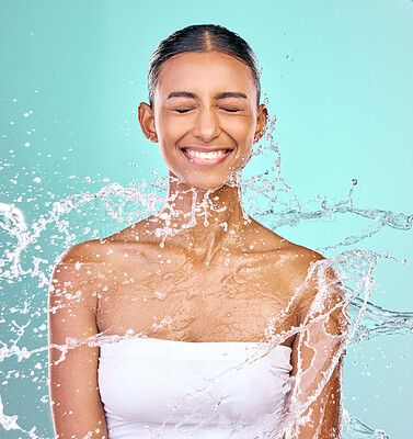 Buy stock photo Woman, washing face and water splash for skin care, hygiene and beauty or dermatology in studio. Excited model with eyes closed and liquid for natural, cosmetics or facial cleaning on blue background