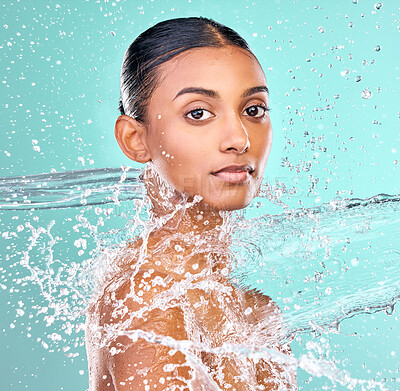 Buy stock photo Indian woman, portrait and water splash for skin care, hygiene and beauty or dermatology in studio. Face of model with liquid for waterproof cosmetics, makeup or facial washing on blue background