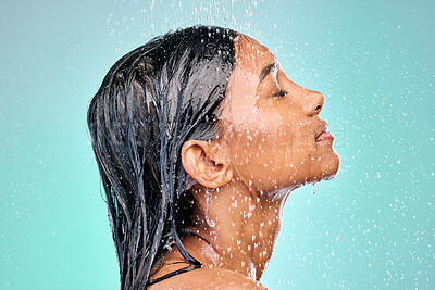 Buy stock photo Studio, shower and face of woman for skincare with wellness, morning routine and safety from bacteria. Dermatology, water drops and Indian girl with facial cleaning for skin health by blue background