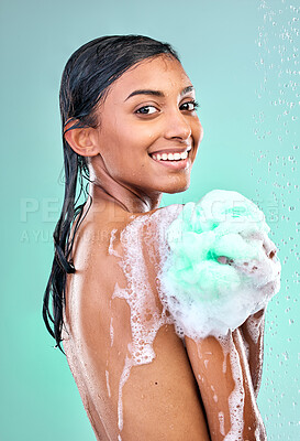 Buy stock photo Shot of an young woman enjoying a soapy shower against a blue background