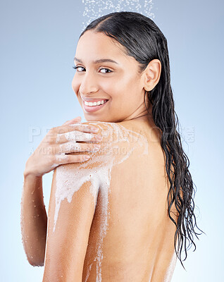 Buy stock photo Studio portrait of an attractive young woman taking a shower against a blue background