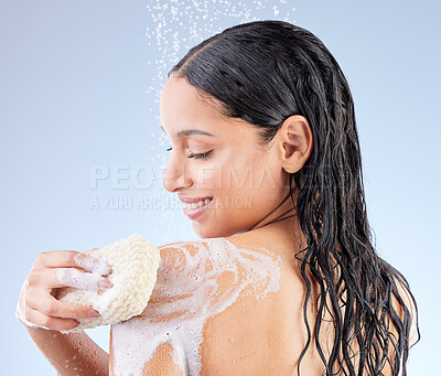 Buy stock photo Studio shot of an attractive young woman taking a shower against a blue background