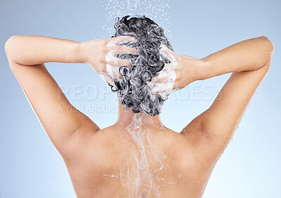 Buy stock photo Studio shot of an unrecognizable young woman taking a shower against a blue background