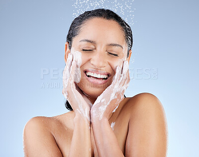 Buy stock photo Studio shot of an attractive young woman taking a shower against a blue background