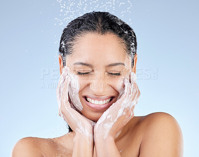 Buy stock photo Studio shot of an attractive young woman taking a shower against a blue background