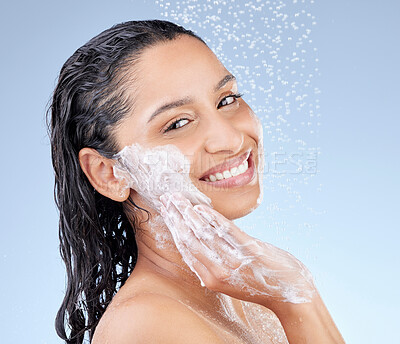 Buy stock photo Studio portrait of an attractive young woman taking a shower against a blue background