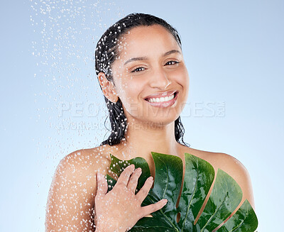 Buy stock photo Studio portrait of an attractive young woman taking a shower against a blue background