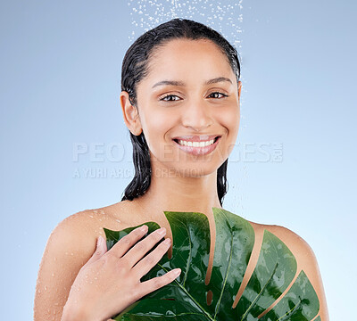 Buy stock photo Studio portrait of an attractive young woman taking a shower against a blue background