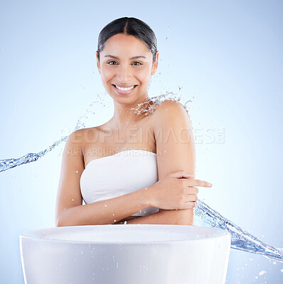 Buy stock photo Shot of a young woman washing herself against a blue background