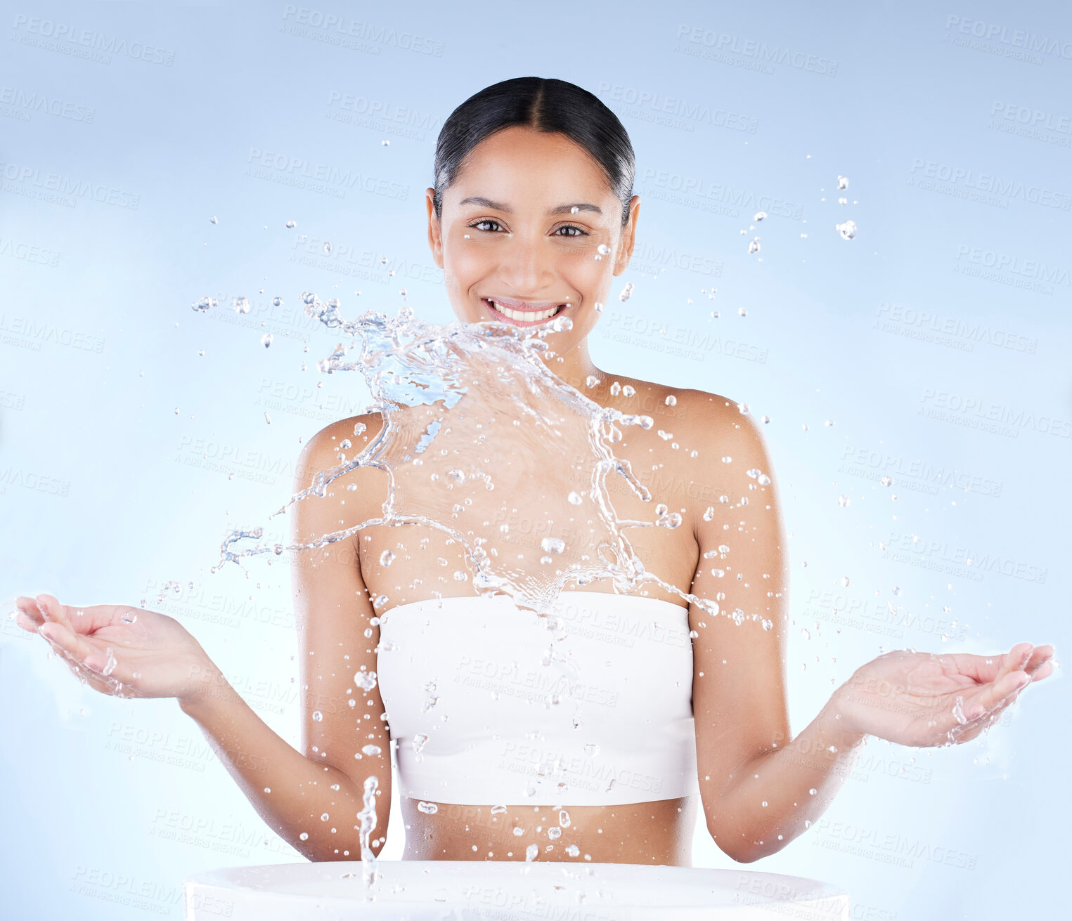 Buy stock photo Shot of a young woman washing herself against a blue background