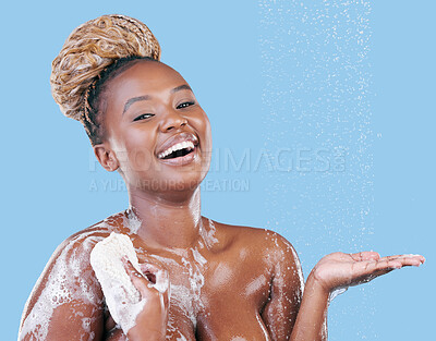 Buy stock photo Studio portrait of an attractive young woman showering against a blue background