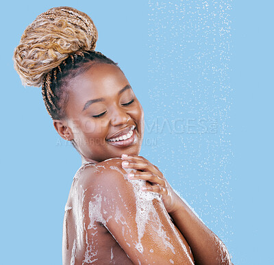 Buy stock photo Studio shot of an attractive young woman showering against a blue background