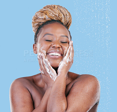 Buy stock photo Studio shot of an attractive young woman showering against a blue background