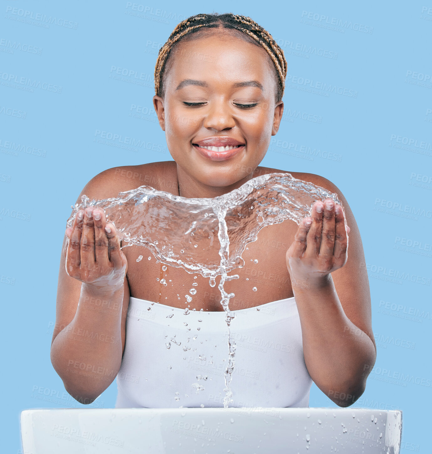 Buy stock photo Water splash, skincare and black woman in studio with natural, beauty and facial routine. Cosmetic, dermatology and African female person washing face with h2o liquid in basin by blue background.