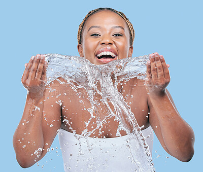 Buy stock photo Portrait, cleaning and black woman washing face, water splash and beauty on blue studio background. African person, smile and model with self care, wet and grooming routine with hygiene and liquid