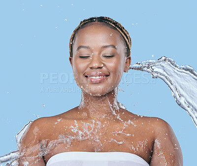 Buy stock photo Water splash, health and black woman in studio with natural, beauty and facial routine for wellness. Cosmetic, dermatology and African female person washing face with h2o liquid by blue background.