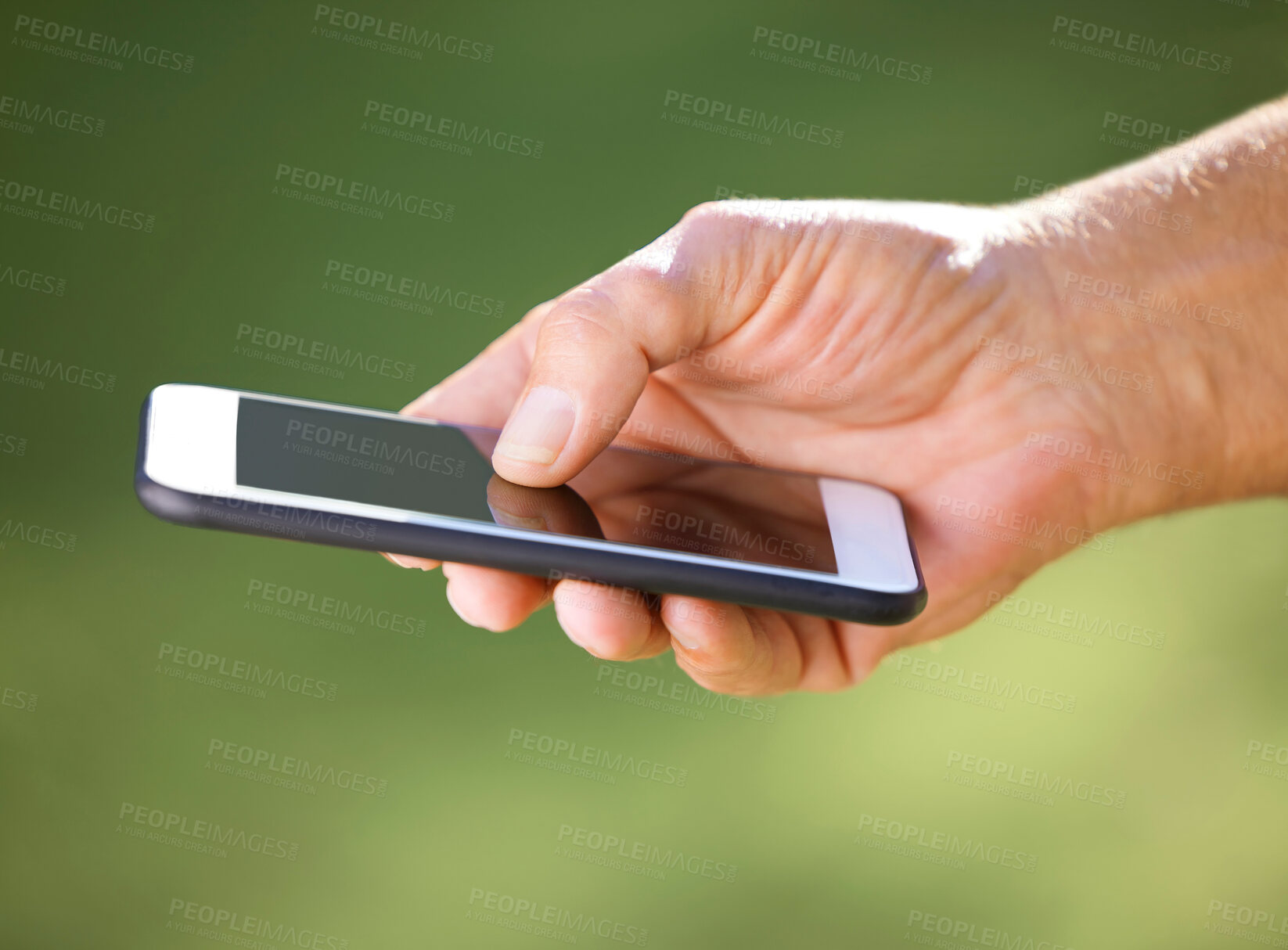 Buy stock photo Shot of an unrecognisable man using a smartphone outdoors