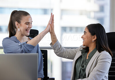 Buy stock photo Shot of two young businesswoman giving each other a high five in an office at work