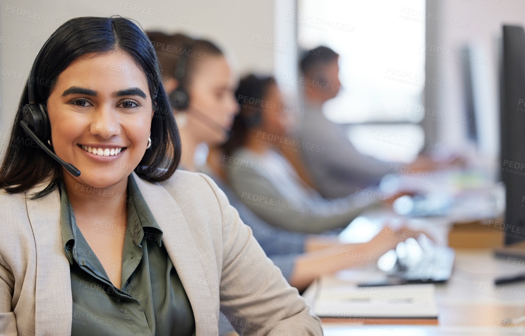 Buy stock photo Portrait of a young call centre agent working in an office with her colleagues in the background