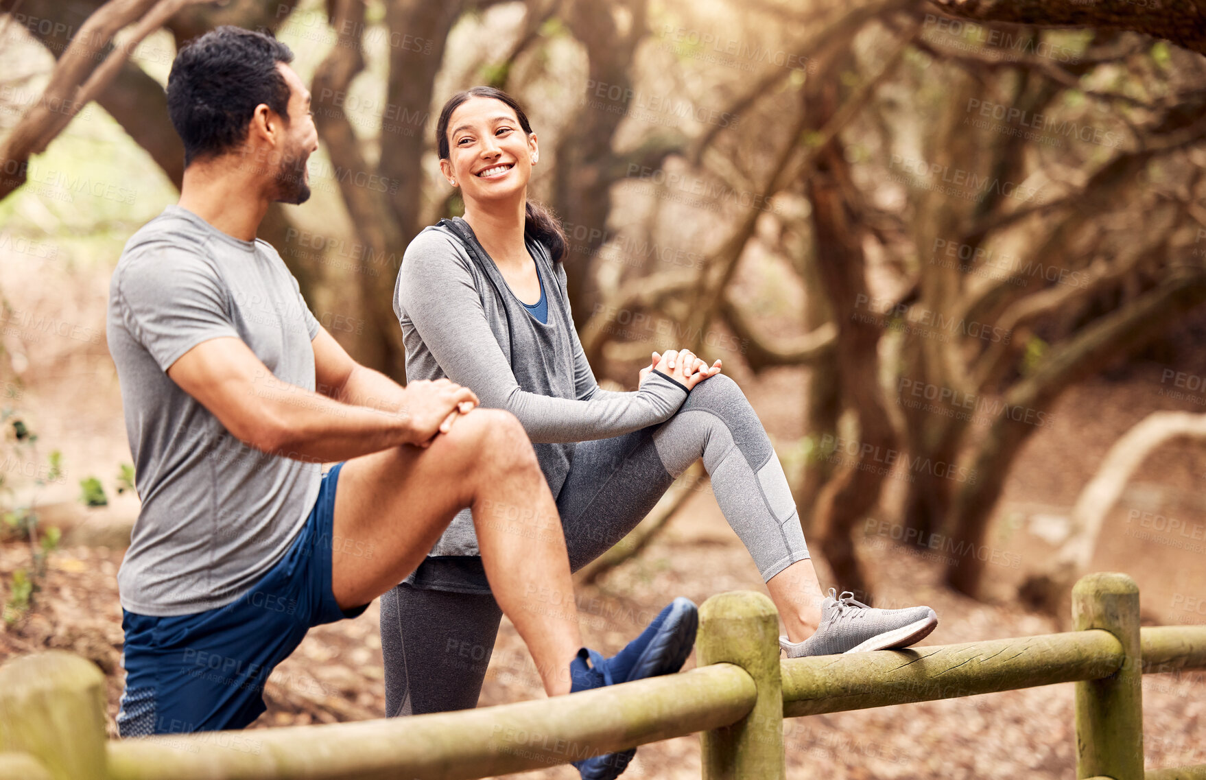 Buy stock photo Stretching, woman and man on fence, couple and outdoor for fitness, action and performance in countryside. Forest, athlete and people with smile, together and training for workout, healthy and park