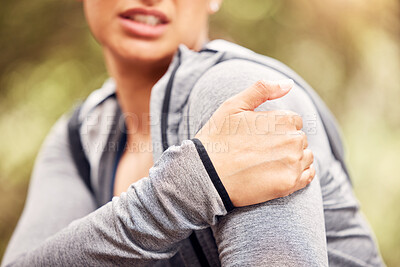 Buy stock photo Shot of an unrecognisable woman experiencing shoulder pain while working out in nature
