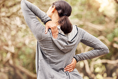 Buy stock photo Rearview shot of a woman experiencing back pain while working out in nature