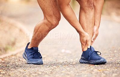 Buy stock photo Shot of an unrecognisable man experiencing ankle pain while working out in nature