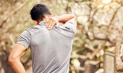 Buy stock photo Rearview shot of an unrecognisable man experiencing neck pain while working out in nature