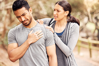 Buy stock photo Shot of an unrecognisable man experiencing pain and being helped by his partner while working out in nature