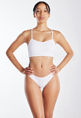 Buy stock photo Shot of a young woman posing in her underwear against a white background