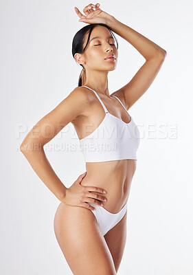 Buy stock photo Shot of a young woman posing in her underwear against a white background
