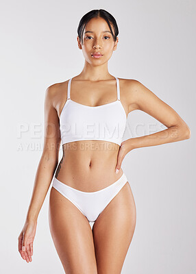 Buy stock photo Shot of a young woman posing in her underwear against a white background