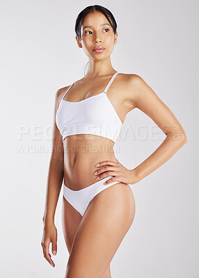 Buy stock photo Shot of a young woman posing in her underwear against a white background