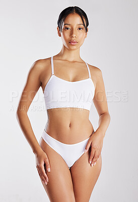 Buy stock photo Shot of a young woman posing in her underwear against a white background