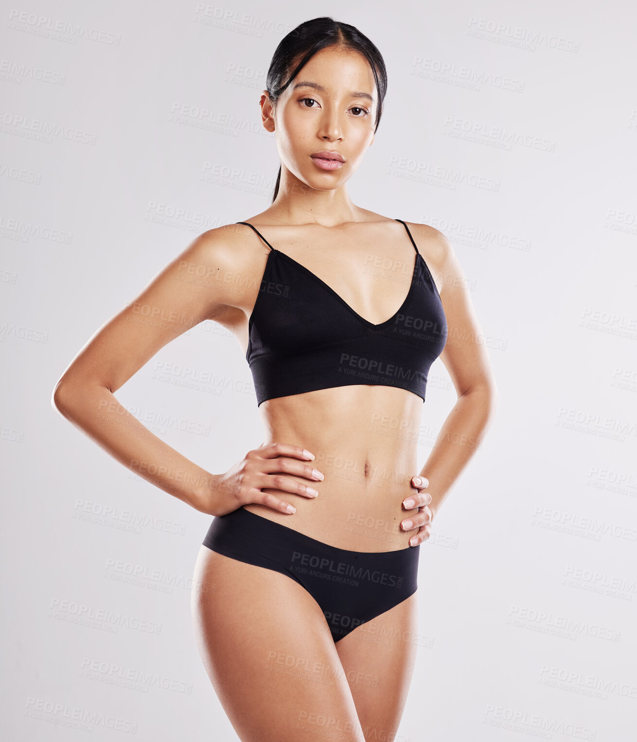 Buy stock photo Shot of a young woman posing in her underwear against a white background