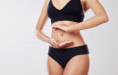 Buy stock photo Cropped shot of a woman forming a frame over her stomach