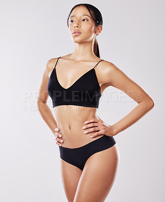 Buy stock photo Shot of a young woman posing in her underwear against a white background