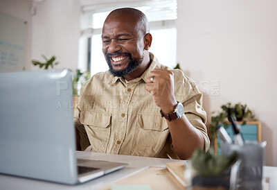 Buy stock photo Shot of a mature businessman using a laptop and looking excited in a modern office