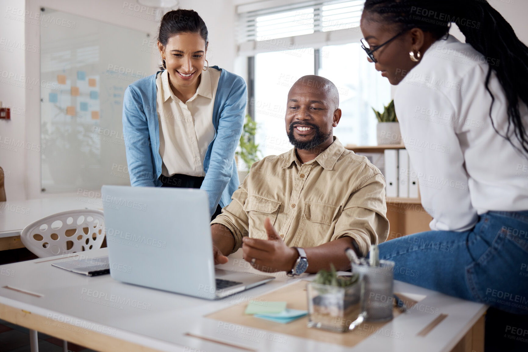 Buy stock photo Shot of a group of businesspeople using a laptop in a modern office