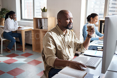 Buy stock photo Shot of a mature businessman using a computer at his desk in a modern office