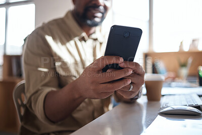 Buy stock photo Shot of an unrecognisable businessman using a smartphone at his desk in a modern office