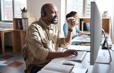 Buy stock photo Shot of a mature businessman using a headset and computer in a modern office while enjoying a cup of coffee