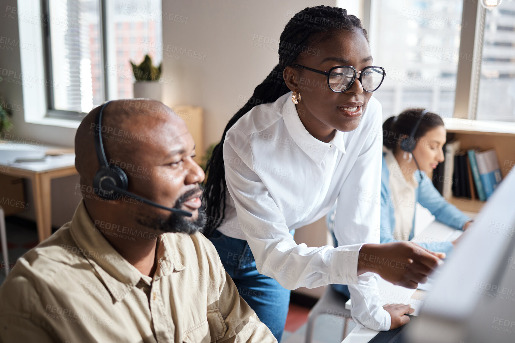 Buy stock photo Shot of a businessman and businesswoman using a headset and computer while working in a modern office