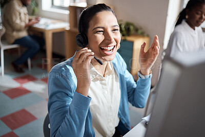 Buy stock photo Shot of a young businesswoman using a headset and computer and looking excited in a modern office